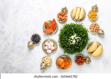 Traditional Azerbaijan holiday Novruz background with green semeni,traditional azerbaijan sweets,shekerbura,qogal,paxlava,mutaki and different nuts and sweets,top view,space for copy