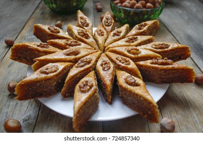 Traditional Azerbaijan Holiday Nowruz Cookies Baklava On White Plate On The Rustic Background With Nuts And Huzelnuts On Green Plate ,flat Lay