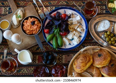 Traditional Azerbaijani breakfast served with traditional bakery qogal, black tea, fresh vegetables, white cheese, eggs with tomatoes, jam and yogurt. View from above