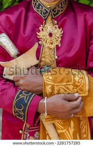 Traditional Balinese male wedding dress, gold jewelry and a ceremonial knife kris. Bali, Indonesia.