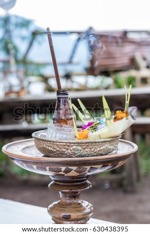 Traditional balinese offerings to gods in Bali with flowers and aromatic sticks. Tropical island Bali, Indonesia.