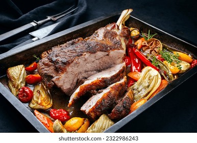 Traditional barbecue lamb shoulder with vegetables and chili served as close-up on a rustic metal tray  - Shutterstock ID 2322986243