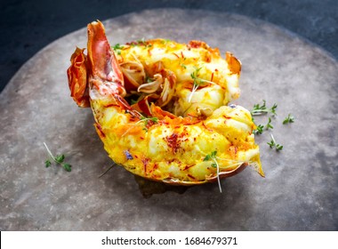 Traditional Barbecue Spiny Lobster Tail Sliced And Offered With Saffron Lemon Sauce As Closeup On A Rustic Modern Design Plate