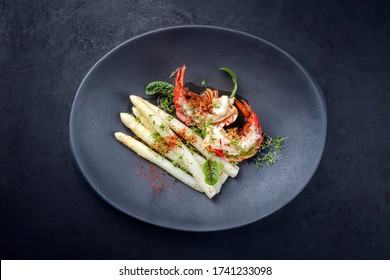 Traditional Barbecue Spiny Lobster Tail Sliced And Offered With White Asparagus And Lettuce As Top View On A Modern Design Plate 