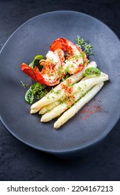 Traditional Barbecue Spiny Lobster Tail Sliced And Offered With White Asparagus And Lettuce As Top View On A Modern Design Plate 