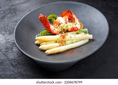 Traditional Barbecue Spiny Lobster Tail Sliced And Offered With White Asparagus And Lettuce As Closeup On A Modern Design Plate 