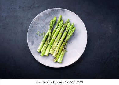 Traditional barbecued green asparagus with herbs as top view on a modern design plate with copy space  - Powered by Shutterstock