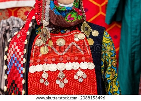 Traditional Bashkir national costumes with monists made of ancient coins and bright red fabric on a mannequin