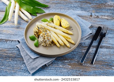 Traditional Bavarian white asparagus with wild garlic- and almond butter dumpling served as a close-up on a Nordic Design plate with text space  - Powered by Shutterstock