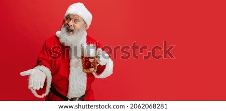 Traditional beer festival. Portrait of senior man wearing Santa Claus costume, holding lager foamed beer glass. Oktoberfest. Concept of holiday, event, festival, sales. Copy space for ad