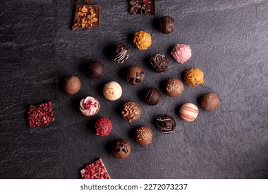 Traditional Belgian chocolate variety over rustic wooden board, decorated with chocolate swirls. - Powered by Shutterstock