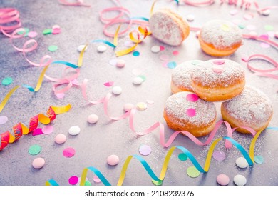 Traditional Berliner for carnival and party. German Krapfen or donuts with streamers and confetti. Colorful carnival or birthday image - Shutterstock ID 2108239376