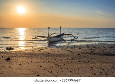 Traditional boat resting on the shore at sunset,