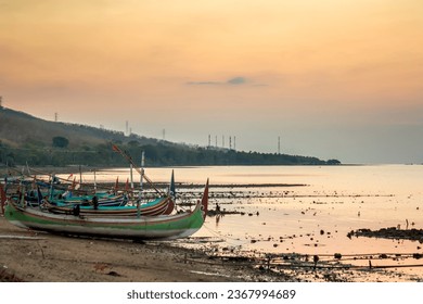 Traditional boat resting on the shore at sunset,