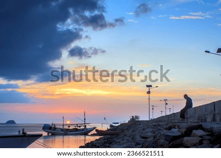 Traditional boats leaning on the pier, at sunset on the coast