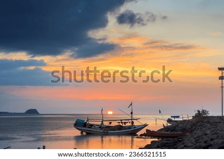 Traditional boats leaning on the pier, at sunset on the coast