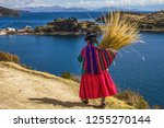 Traditional bolivian woman in traditional dress, walking trought the Sun island in lake titicaca, Bolivia