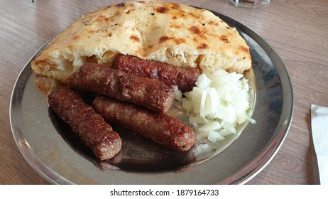 Traditional Bosnian cuisine dish ćevapćići served with somun and diced onions. 
