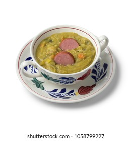 Traditional bowl with Dutch pea soup and smoked sausage on white background