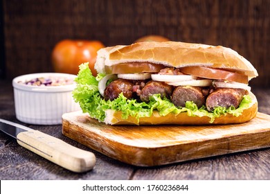 traditional Brazilian sandwich of bread with sausage, tomato, onion and lettuce. Crispy salt bread with roasted or fried sausage.