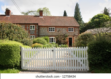Traditional Brick and Flint English Village Cottage with picket gate to the front
