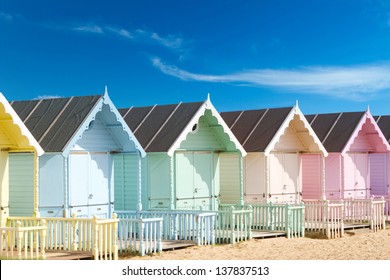 Traditional British beach huts on a bright sunny day