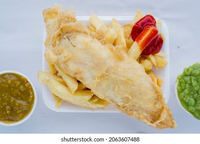 Traditional British Fish And Chips With Ketchup, Mushy Peas Or Curry Sauce