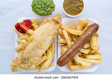 Traditional British Fish And Chips With Ketchup, Mushy Peas Or Curry Sauce