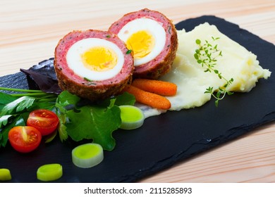 Traditional British Picnic Food - Delicious Scotch Egg Cut In Halves With Potato Mash, Vegetables And Greens