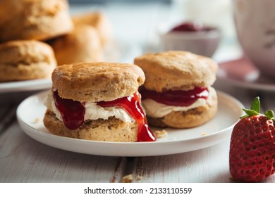Traditional british scones with clotted cream and strawberry jam for tea time - Shutterstock ID 2133110559