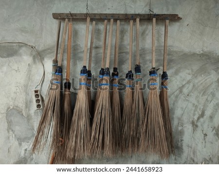 A traditional broom made from dried coconut tree sticks, usually used to clean the yard of the remaining leaves that have fallen from the trees, is now hanging neatly on the wall and there is an elect