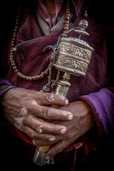 A Traditional Buddhist Prayer Wheel In The Hand Of An Old Man In The Indian Himalaya. Diskit, Ladakh, India