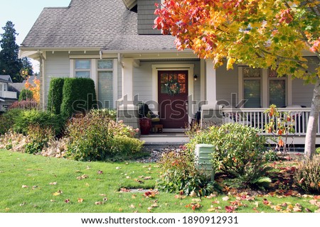 Traditional Canadian house with a large front yard. Beautiful new home with a cozy porch in autumn. 