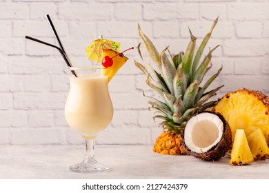 Traditional caribbean cocktail pina colada in a glass, garnished with a slice of pineapple.