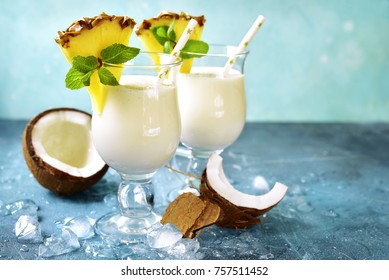Traditional caribbean cocktail pina colada in a glasses on a blue slate,stone or concrete background.
