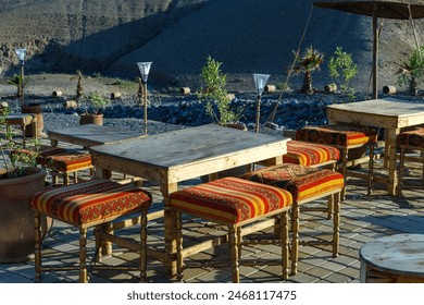 Traditional chairs and tables set up in a picturesque outdoor café in the heart of Marrakesh, showcasing Moroccan culture and design - Powered by Shutterstock