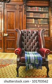 Traditional Chesterfield Armchair With Tartan Blanket In Classical Library Room