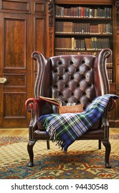 Traditional Chesterfield Armchair With Tartan Blanket In Classical Library Room