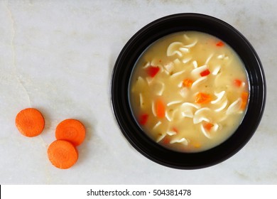 Traditional Chicken Noodle Soup, Overhead View On White Marble Background