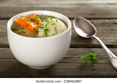 Traditional Chicken Soup With Dumplings On A Rustic Wooden Table With Silver Spoon