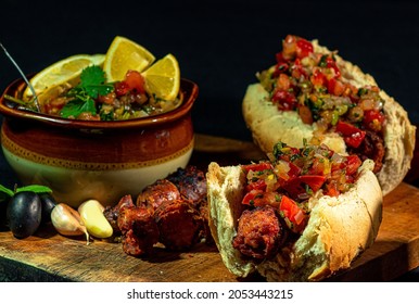 traditional chilean choripan and bowl with pebre, roast from national holidays in chile, chorizo sandwich