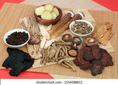 Traditional Chinese Herbs Used As A Tonic In Herbal Medicine On Bamboo And Red Background. Alternative Medicine Health Care Concept. Flat Lay.