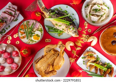 Traditional Chinese lunar New Year dinner table, party invitation, menu background with pork, fried fish, chicken, rice balls, dumplings, fortune cookie, nian gao cake, noodles, chinese decorations - Shutterstock ID 2229791851