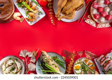 Traditional Chinese lunar New Year dinner table, party invitation, menu background with pork, fried fish, chicken, rice balls, dumplings, fortune cookie, nian gao cake, noodles, chinese decorations - Shutterstock ID 2245039001