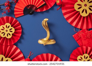 Traditional Chinese New Year decorations on a blue background with red paper fans, gold snake, and festive ornaments. Lunar New Year 2025, Year of the Snake concept. - Powered by Shutterstock