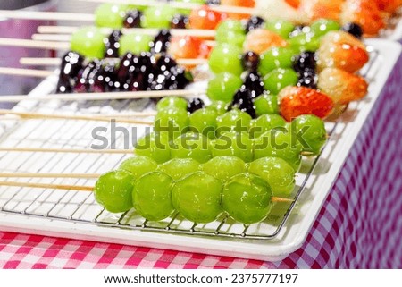 traditional Chinese snack Tanghulu or mix Fruits on skewers coated in a crispy shell of sugar