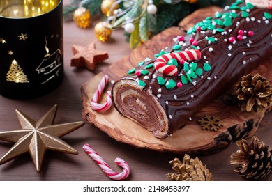 Traditional chocolate trunk cake or log cake on table with Christmas decorations, top view - Shutterstock ID 2148458397