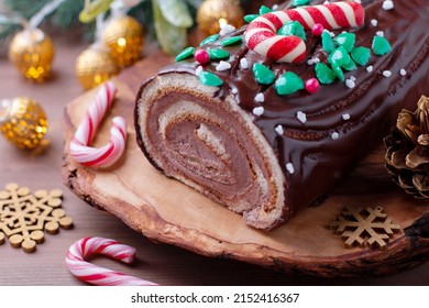Traditional chocolate trunk cake or log cake on table with Christmas decorations, top view - Shutterstock ID 2152416367