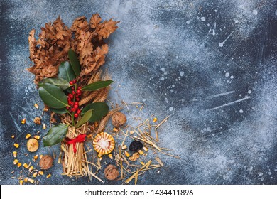Traditional Christmas decoration in Serbia called Badnjak, Oak branch on rustic blue  surface. Top view, blank space, vintage toned image 