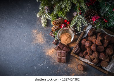 Traditional Christmas dessert, homemade chocolate truffles, with dark chocolate slices, winter spices and christmas tree decor on dark  background. copy space